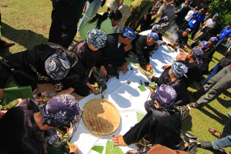 Setelah berdoa, masyarakat kampung budaya sindang barang saling berebut kue yang telah disediakan
