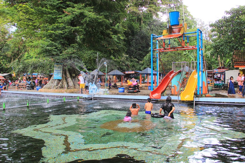 Pemandian Cibulan menggabungkan hiburan wahana bermain air dengan keberadaan mitos ikan dewa