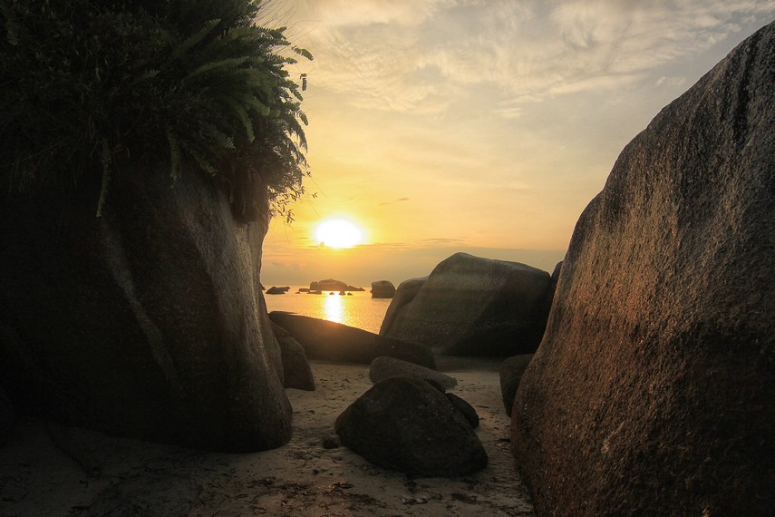 Menyaksikan terbitnya matahari dari sela-sala batu granit menjadi pengalaman yang tidak terlupakan di Pantai Tanjung Kelayang