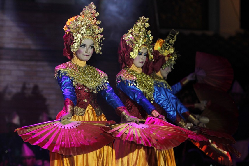 Penari kipas serumpun mengenakan baju kurung yang didominasi oleh warna keemasan sebagai ciri khas adat Sumatera Selatan