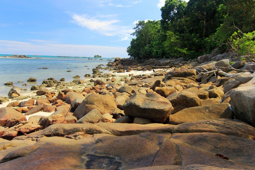 Batu-batuan dan hijaunya pepohonan menjadi penghias Pantai Bukit Berahu