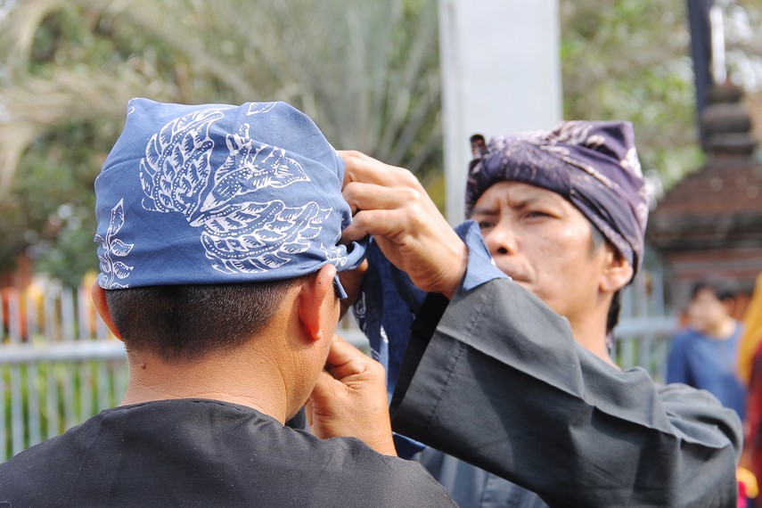 Masyarakat Kampung Budaya Sindang Barang saling memakaikan iket atau totopong sebelum melakukan tradisi helaran dongdang