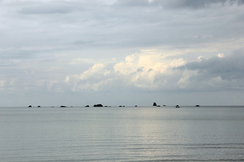 Memandangi laut dengan panorama batu granit di tengah hamparan air menjadi daya tarik dari pantai ini