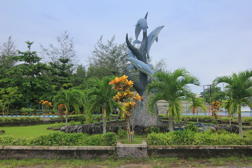 Patung menara lumba-lumba yang menjadi lambang Kota Belitung juga menghiasi taman yang ada di Pantai Tanjung Pendam