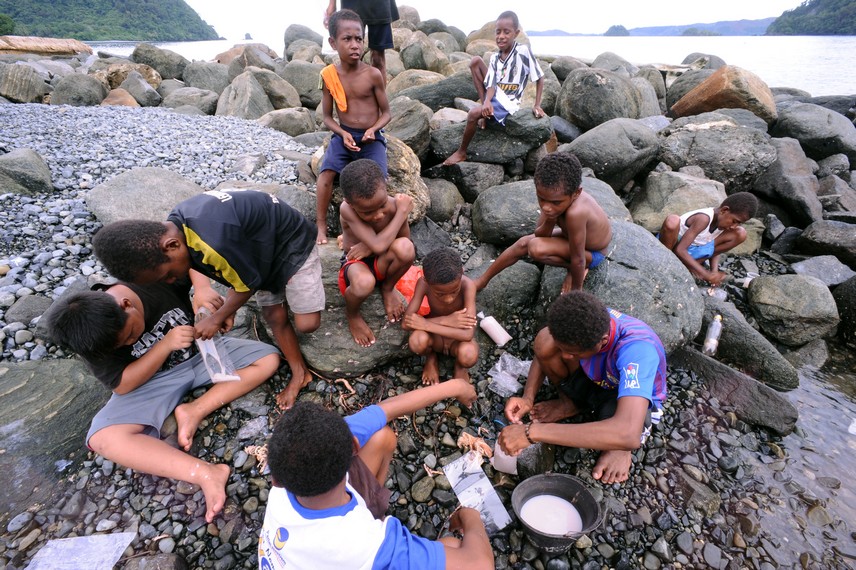 Anak-anak Desa Tablanusu asyik bermain sambil menangkap ikan di pinggir pantai