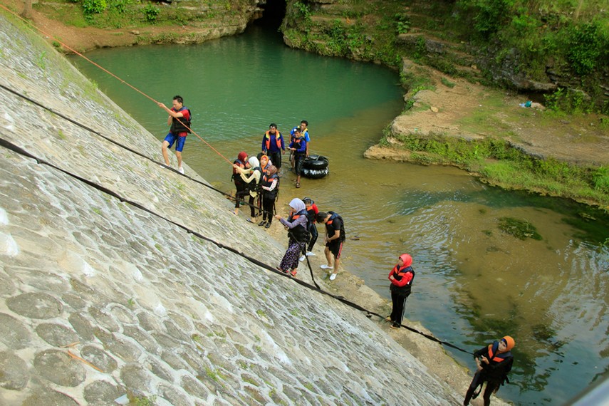 Pengunjung harus memanjat tepi sungai dengan tali tambang untuk keluar dari lokasi wisata ini